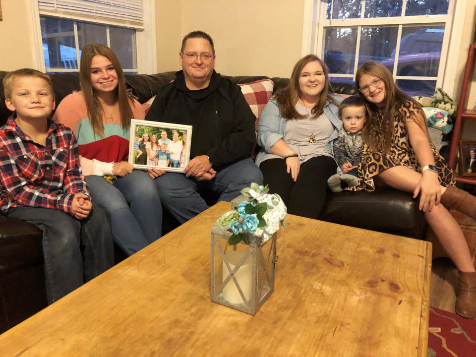 Keith Michael, third from left, sits on a sofa with his children, from left, Hunter, Jessica, Sara, Houston and Holly, at their home on Friday, Nov. 13, 2020, in Jonesboro, Ark. Among the victims of the coronavirus is Michael's wife, fourth-grade Arkansas teacher Susanne Michael, who died less than three months after celebrating the adoption of three of the children. (AP Photo/Adrian Sainz)