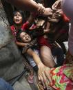 epaselect epa04044221 Filipino resident Brix Mercado, 27, (C) is shielded by his family to prevent the local police from arresting him during a demolition of shanties at Sitio San Roque in Quezon City, east of Manila, Philippines, 27 January 2014. Throwing rocks, pillboxes, and even human waste, illegal settlers barricaded the demolition team in Baranggay Bagong Pag-asa. Four residents were arrested and twelve were reported injured. Residents report receiving cash from 300 to 450 US dollar in exchange for their voluntary relocation. Earlier, hundreds of the urban poor marched to the city hall in protest of the demolition that will pave the way for the rise of a business district. EPA/DENNIS M. SABANGAN