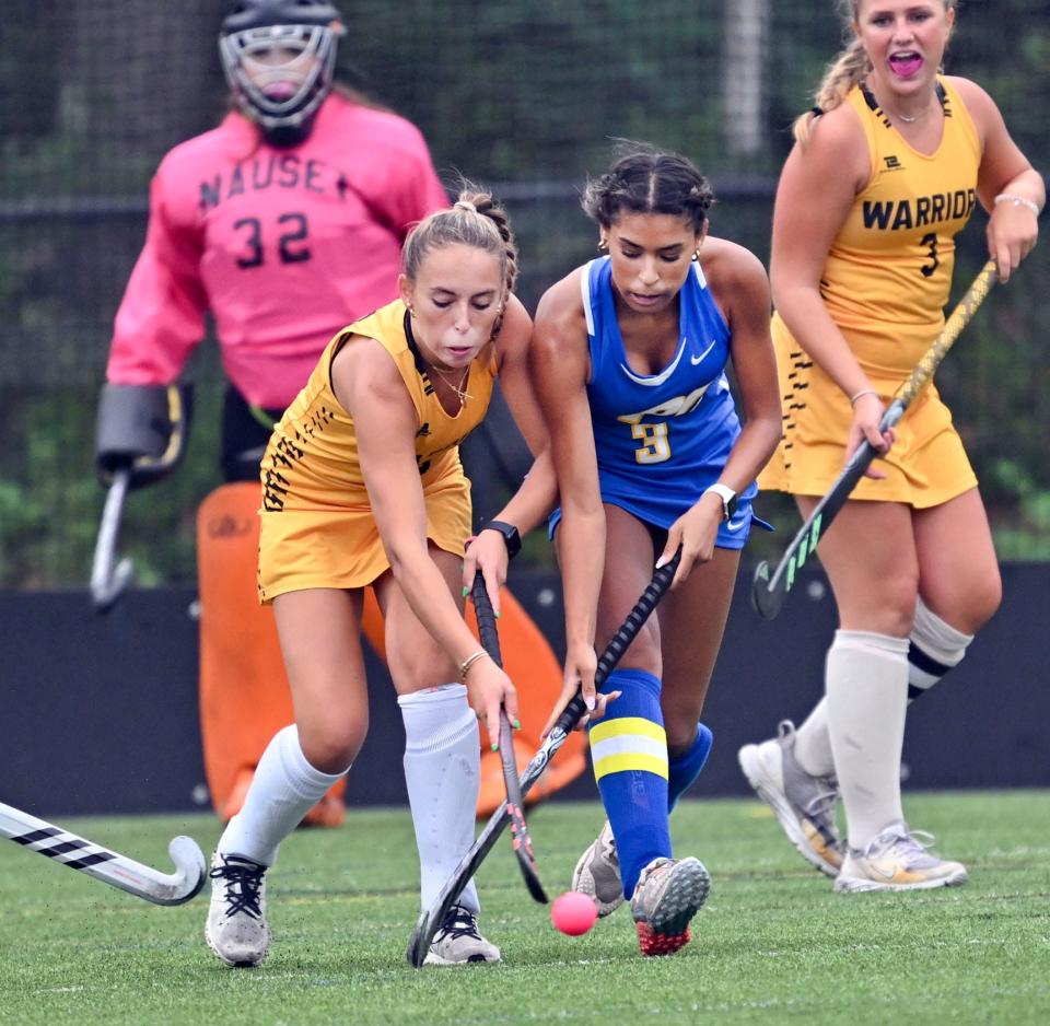 Chloe Hand of Nauset knocks the ball away from Kaylee Anthony of St. John Paul II in field hockey.