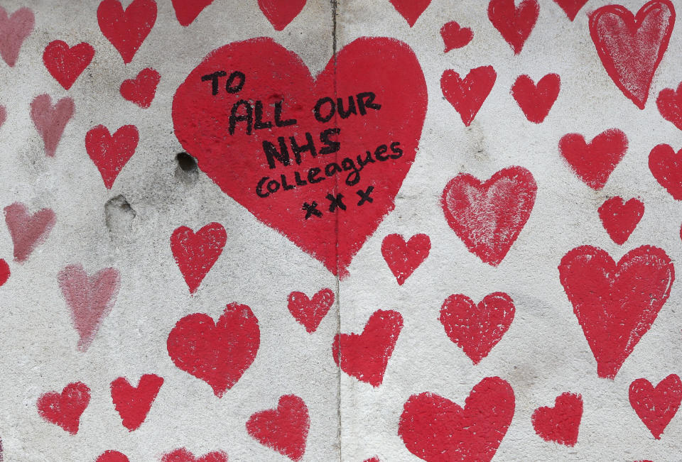 A close up of the hearts on the 'The National COVID Memorial Wall' on the south bank of the Thames in front of St. Thomas' hospital and opposite the House of Parliament in London, Sunday April 4, 2021. Hearts are being drawn onto the wall in memory of the many thousands of people who have died in the UK from coronavirus, with organizers hoping to reach their target of 150,000 hearts by the middle of next week. (AP Photo/Tony Hicks)