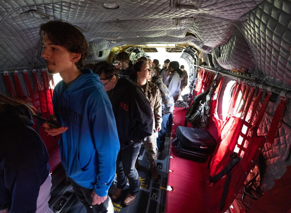 Perry and McKinley Junior ROTC students tour the inside of a Chinook helicopter that landed behind the Perry high school on Thursday.
