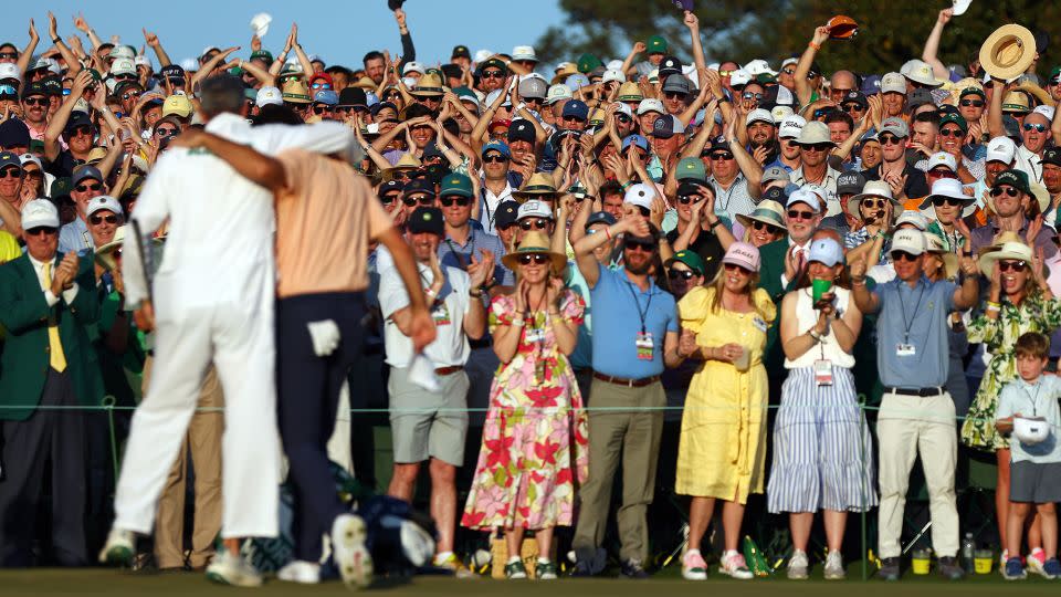 Patrons cheer as Scottie Scheffler and his caddie, Ted Scott, celebrate on the 18th green after winning the Masters. - Maddie Meyer/Getty Images