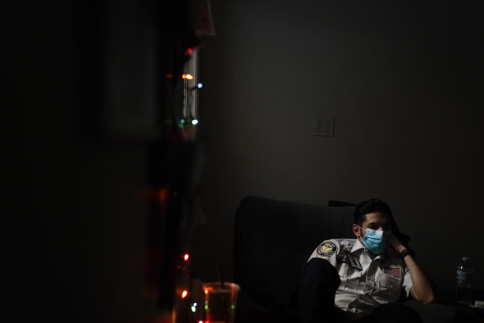 Emergency medical technician Joshua Hammond, 25, of Emergency Ambulance Service, watches TV while on standby for a dispatch call in Placentia, Calif., Friday, Jan. 8, 2021. (AP Photo/Jae C. Hong)