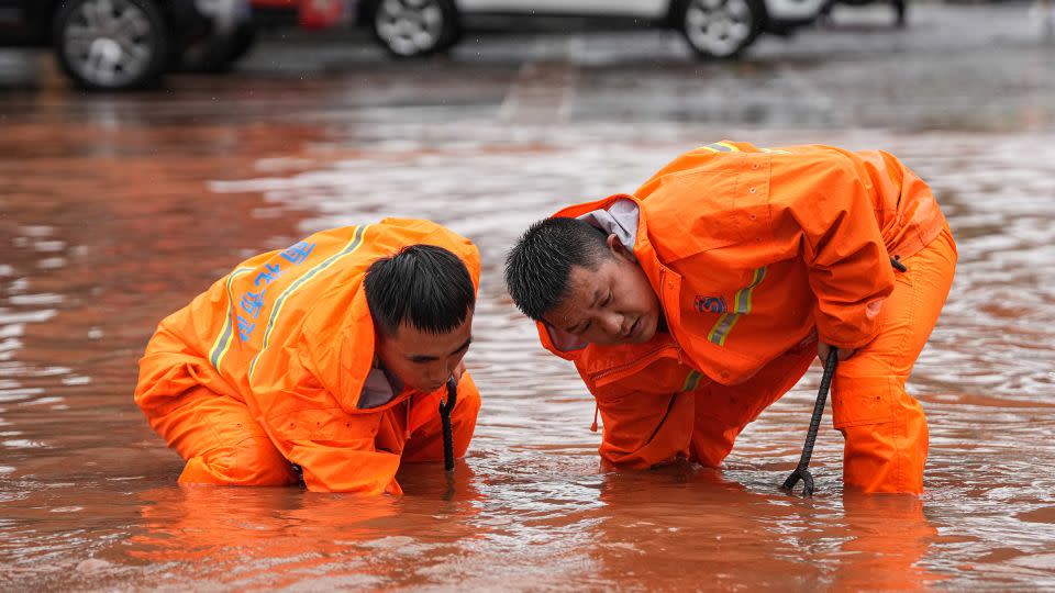 Los trabajadores dragan una alcantarilla en una calle inundada en Changsha, provincia de Hunan, el 24 de junio. - AFP/Getty Images