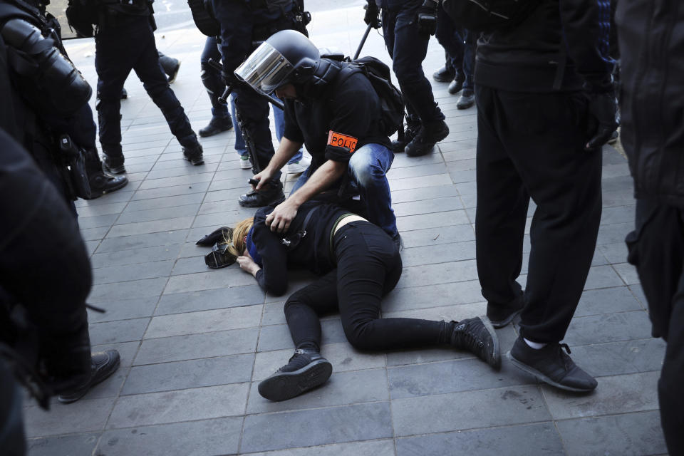 A police officer attends to a woman during a yellow vest demonstration in Paris, Saturday, April 20, 2019. French yellow vest protesters are marching anew to remind the government that rebuilding the fire-ravaged Notre Dame Cathedral isn't the only problem the nation needs to solve. (AP Photo/Francisco Seco)