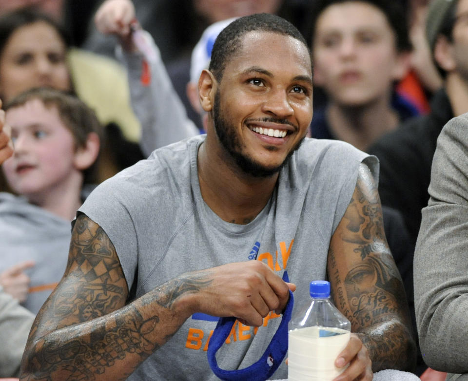 New York Knicks' Carmelo Anthony smiles as he watches from the bench during the fourth quarter of an NBA basketball game against the Charlotte Bobcats Friday, Jan. 24, 2014, at Madison Square Garden in New York. Anthony scored 62 points as the Knicks won 125-96. (AP Photo/Bill Kostroun)