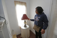 "Look how high the water got in my parent's home," says Natasha Colton, as she presses the fabric on a floodwater-soaked lamp shade in her parent's home in northeast Jackson, Miss., Wednesday, Feb. 19, 2020. The family said although they were warned about the potential of being flooded out, the waters came so swiftly they could only manage to take some clothes, personal papers and photographs away before the waters entered their home. (AP Photo/Rogelio V. Solis)