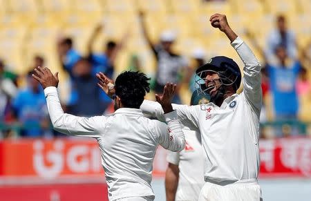 Cricket - India v Australia - Fourth Test cricket match - Himachal Pradesh Cricket Association Stadium, Dharamsala, India - 27/03/17 - India's Ravindra Jadeja (L) and Cheteshwar Pujara celebrate the dismissal of Australia's Shaun Marsh. REUTERS/Adnan Abidi