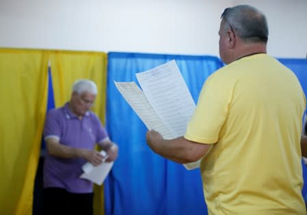 Voters hold ballots at a polling station during Ukraine's parliamentary election in Kiev