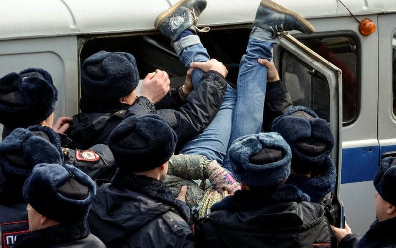 Police officers detain an opposition supporter during a rally in Vladivostok, Russia