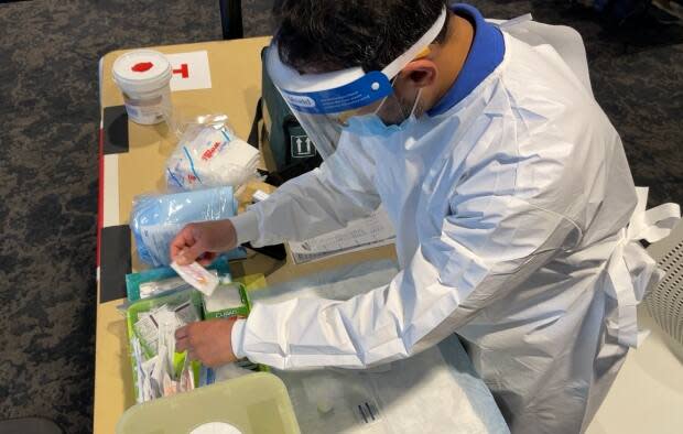 A doctor gets ready to administer his first Moderna vaccine shot of the day.