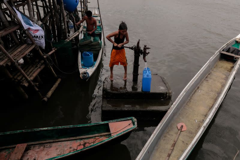 The Wider Image: Rising seas threaten early end for sinking village in Philippines