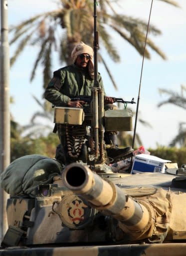 A soldier loyal to Libyan leader Moamer Kadhafi is seen atop a tank as his squadron pushes into the border town of Zawiya in early March