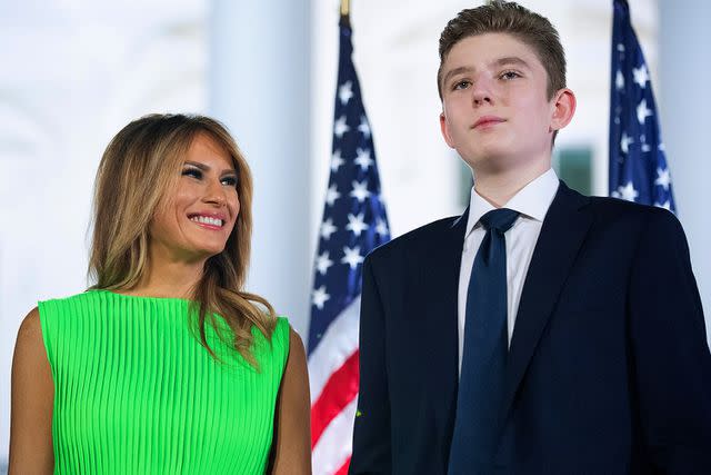 <p>Chip Somodevilla/Getty Images</p> Melania Trump (L) looks at her son Barron Trump