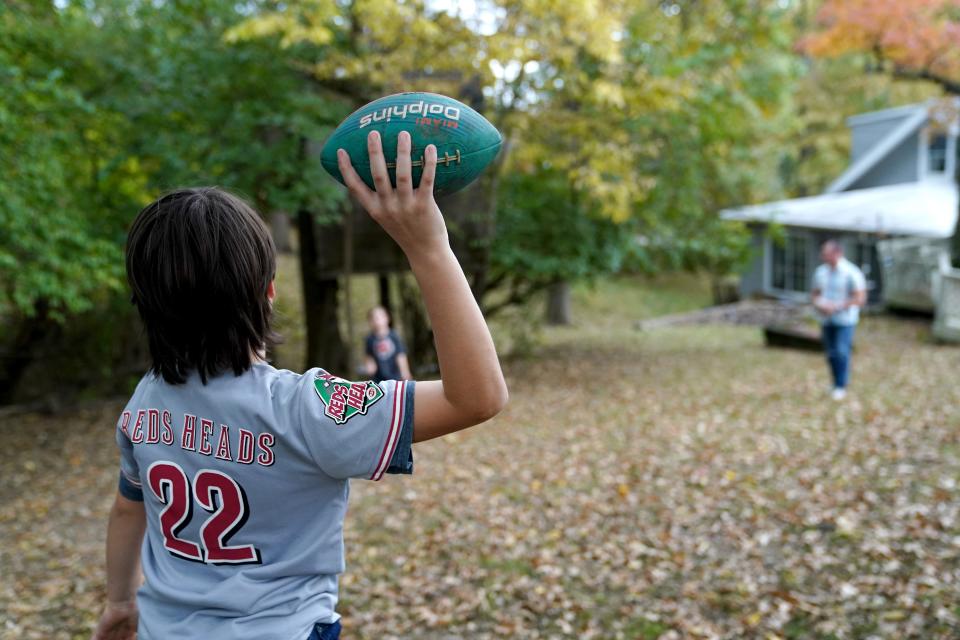 Brandon Long throws the football and kicks the soccer ball around with his sons, Eliah, 11, Mcaiah, 9 and Gideon, 3, in the backyard at their home in Fort Thomas, Kentucky. The family has decided not to pursue playing organized contact football following the sudden cardiac arrest of Buffalo Bills defensive back Damar Hamlin earlier this year.