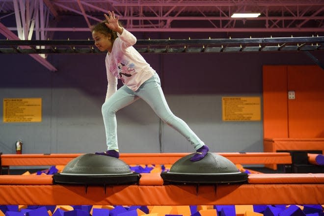 Leila New plays on a balance beam in December 2018, at Surge Adventure Park in Hope Mills.