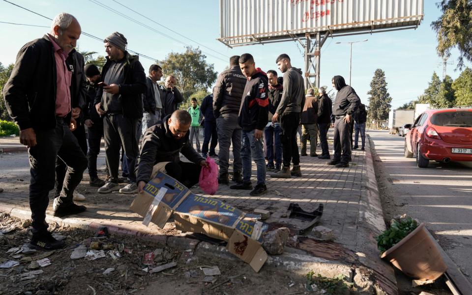 People inspect the site where six Palestinians were killed by an Israeli airstrike in the West Bank city of Jenin on Sunday