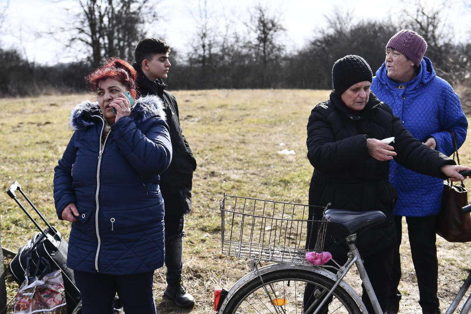 People call their relatives to pick them up at the Hungarian-Ukrainian border, in Barabas, Hungary, Friday, Feb 25, 2022. Hungary has extended legal protection to those fleeing the Russian invasion. (AP Photo/Anna Szilagyi)