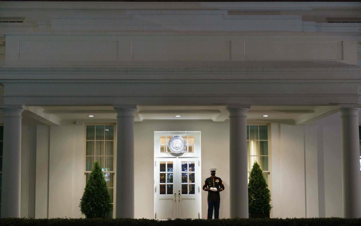 A US Marine stands guard outside of the West Wing of the White House in Washington, DC , a sign that US President Donald Trump could be in the Oval Office - AFP