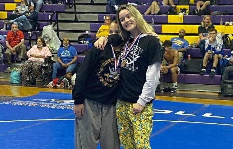 East Henderson's Eva Keefauver, right, poses after winning the 145-pound weight class title at the Jolly Roger Invitational on Saturday.