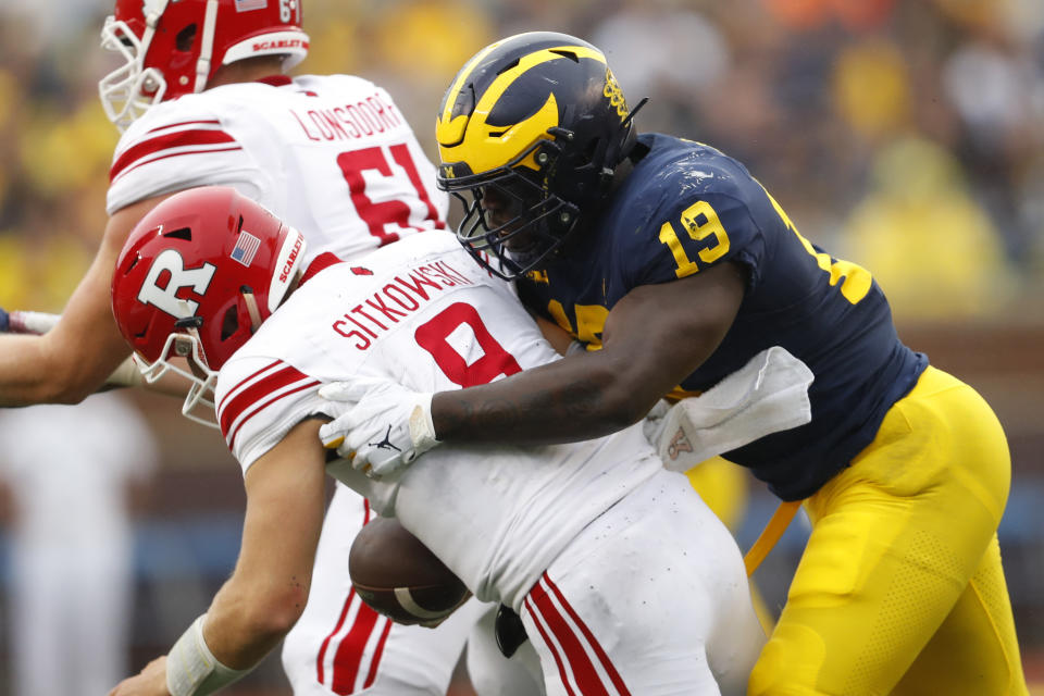 FILE - In this Saturday, Sept. 28, 2019, file photo, Michigan defensive lineman Kwity Paye (19) sacks Rutgers quarterback Artur Sitkowski (8) in the first half of an NCAA college football game, in Ann Arbor, Mich. Michigan has been good, not great, under coach Jim Harbaugh. Michigan defensive end Kwity Paye said the 19th-ranked team is under the radar and the Wolverines have taken a lot of punches from people, criticizing the relatively underwhelming state of the program. (AP Photo/Paul Sancya, File)