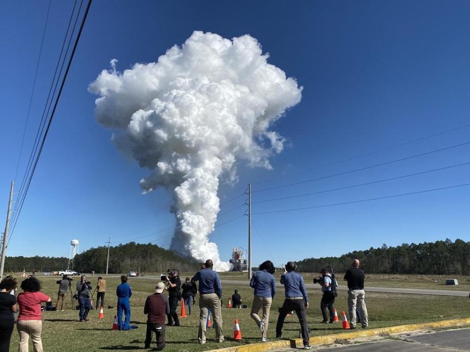 As reporters and photographers look on, a towering plume of steam billows into the Mississippi sky as the four RS-25 engines powering the first stage of NASA's Space Launch System rocket fire during an eight-minutes test run.  / Credit: William Harwood/CBS News