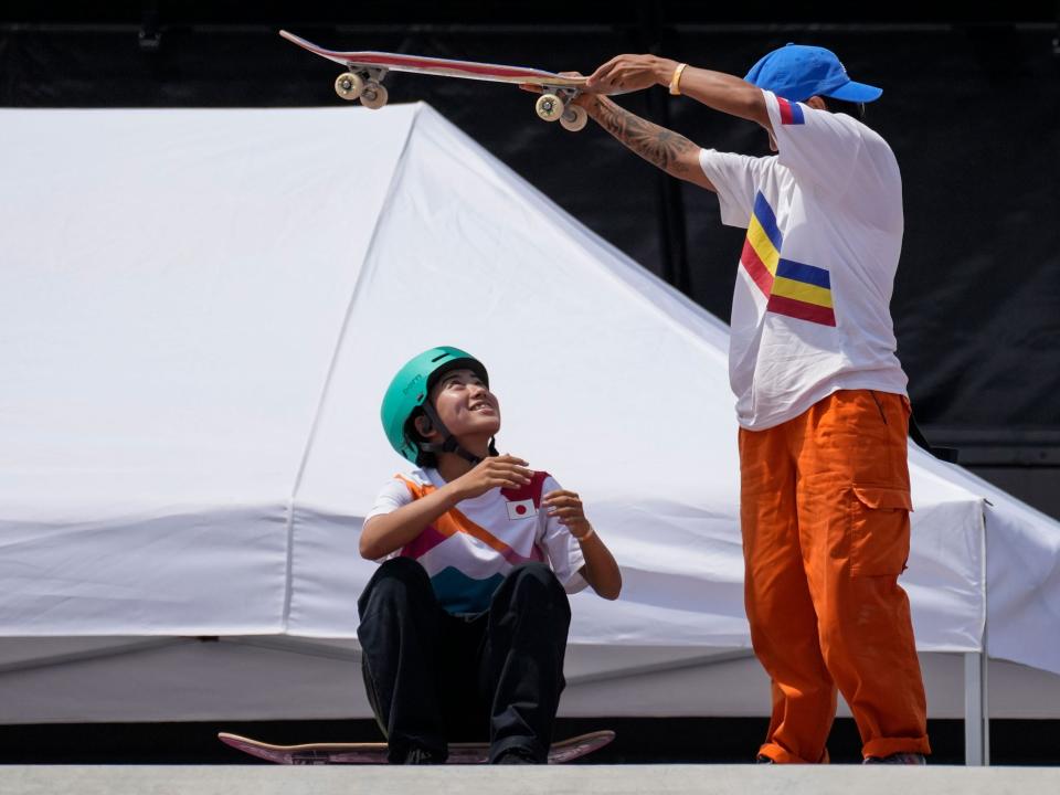 Margielyn Didal of Philippines uses her skateboard to provide shade from the sun to Funa Nakayama of Japan at Tokyo 2021