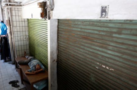 A man sleeps near next to a closed warehouse at Tanah Abang market in Jakarta, Indonesia, September 6, 2018.  REUTERS/Willy Kurniawan