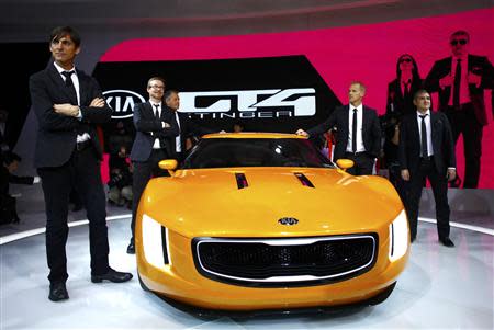 Tom Kearns (L), Kia Chief Designer, and members of his design team pose with the GT4 Stinger concept car during the press preview day of the North American International Auto Show in Detroit, Michigan January 13, 2014. REUTERS/Joshua Lott