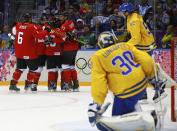 Canada's Jonathan Toews celebrates his goal with his linemates after scoring on Sweden's goalie Henrik Lundqvist (30) as Sweden's Jonathan Ericsson skates past during the first period of their men's ice hockey gold medal game at the Sochi 2014 Winter Olympic Games February 23, 2014. REUTERS/Brian Snyder (RUSSIA - Tags: OLYMPICS SPORT ICE HOCKEY)