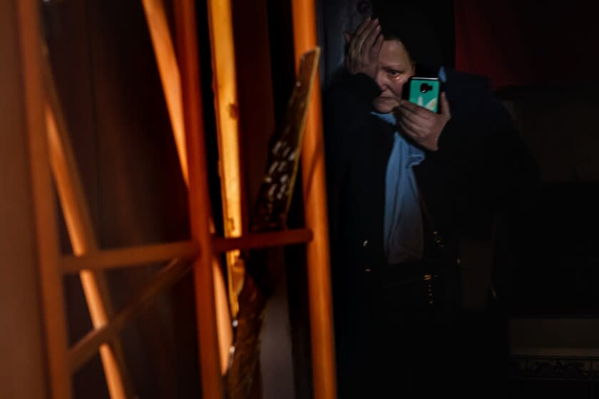 KYIV, UKRAINE -- MARCH 18, 2022: A woman sits in a dark bathroom weeps as she makes a phone call, in a home damaged by what authorities are calling a Russian bombardment in Kyiv, Ukraine, Friday, March 18, 2022. (MARCUS YAM / LOS ANGELES TIMES)