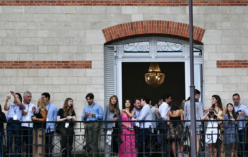 Spectators wait on a balcony before the opening ceremony of the Paris 2024 Olympic Games in Paris on July 26, 2024. / Credit: MANAN VATSYAYANA/AFP via Getty Images