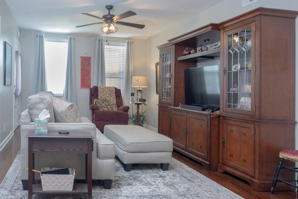 The well-lit living room features comfortable seating along with plenty of storage for their memorabilia.