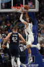 Milwaukee Bucks center Brook Lopez (11) scores the game-winning basket against Dallas Mavericks defenders Dorian Finney-Smith (10) and Maxi Kleber (42) in an NBA basketball game in Dallas, Friday, Dec. 9, 2022. The Bucks won 106-105. (AP Photo/LM Otero)