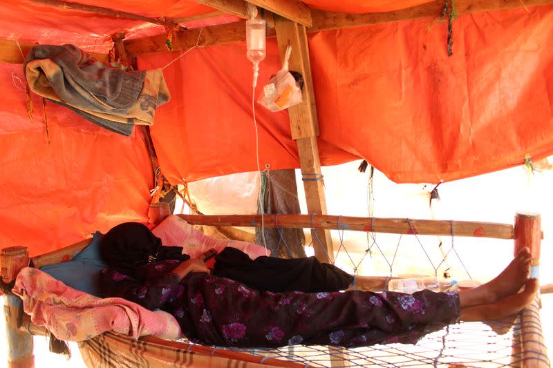 Woman lies in her hut as she recuperates from dengue fever at a camp for internally displaced in Abs of Hajja province