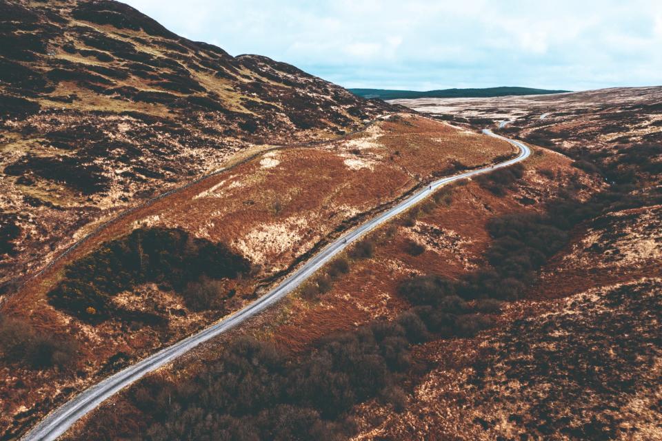 Riders on a gravel track in Scotland shot from a drone