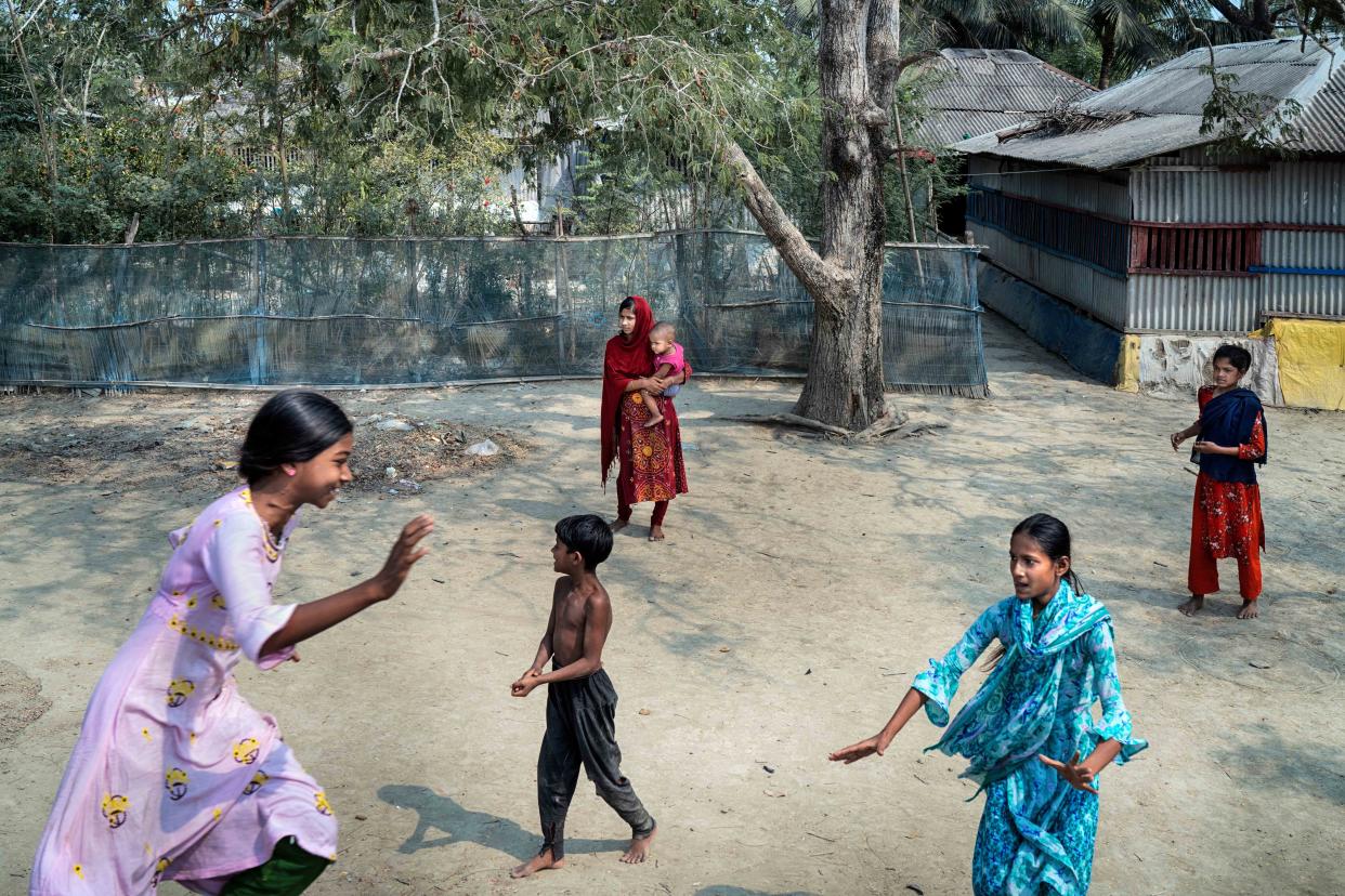 Children play as Sakila Akhtar, 12, carries her daughter Maria in Satkhira, Bangladesh. (Fabeha Monir for NBC News)