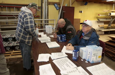 A Flint resident (L) picks up a replacement water filter at a fire station in Flint, Michigan January 13, 2016. REUTERS/Rebecca Cook