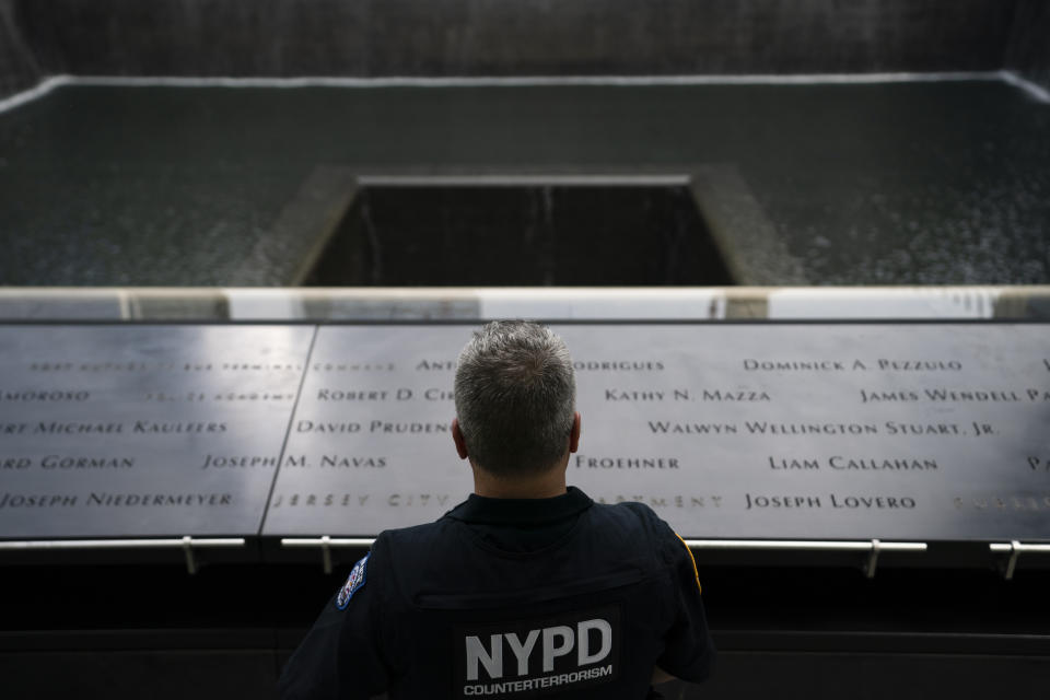 NYPD officer Michael Dougherty, a 25-year veteran, stands beside the south reflecting pool of the 9/11 Memorial & Museum where names of his deceased colleagues and friends are displayed, Monday, Aug. 16, 2021, in New York. A close friend of Dougherty's family, Richard Dunston, worked in the towers on the day of the attacks. His body was never found. "So every morning we'll do walk arounds on the piece of the plaza where the towers stood," Dougherty said. "If we see something on the panel we'll make sure to wipe it off, and I see their names and I'll touch them. You know, I'm here looking over them." (AP Photo/John Minchillo)