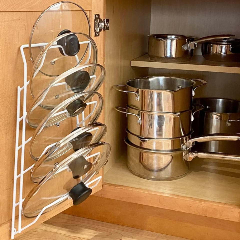 Inside of a cabinet with a lid organizer mounted on the inside of the door