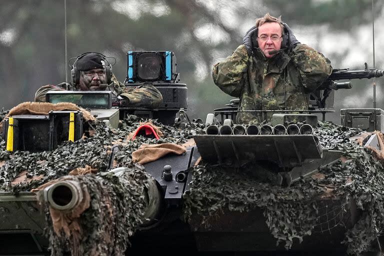 El ministro de Defensa alemán, Boris Pistorius, a la derecha, sentado en un tanque Leopard 2 en el batallón de tanques 203 de la Bundeswehr en el cuartel del mariscal de campo Rommel en Augustdorf, Alemania, el miércoles 1 de febrero de 2023. (AP/Martin Meissner)