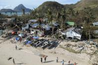 An aerial view shows damaged houses, as residents wave for help after Typhoon Haiyan hit a village in Panay island, in northern Iloilo Province, central Philippines November 9, 2013. Typhoon Haiyan, the strongest typhoon in the world this year and possibly the most powerful ever to hit land battered the central Philippines on Friday, forcing millions of people to flee to safer ground, cutting power lines and blowing apart houses. Haiyan, a category-5 super typhoon, bore down on the northern tip of Cebu Province, a popular tourist destination with the country's second-largest city, after lashing the islands of Leyte and Samar with 275 kph (170 mph) wind gusts and 5-6 meter (15-19 ft) waves. REUTERS/Leo Solinap (PHILIPPINES - Tags: ENVIRONMENT DISASTER)