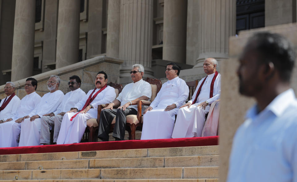 Sri Lankan president Gotabaya Rajapaksa, seated third right, sits for photographs with his new cabinet members in Colombo, Sri Lanka, Friday, Nov. 22, 2019. Rajapaksa, who was elected last week, said he would call a parliamentary election as early as allowed. The parliamentary term ends next August, and the constitution allows the president to dissolve Parliament in March and go for an election. (AP Photo/Eranga Jayawardena)