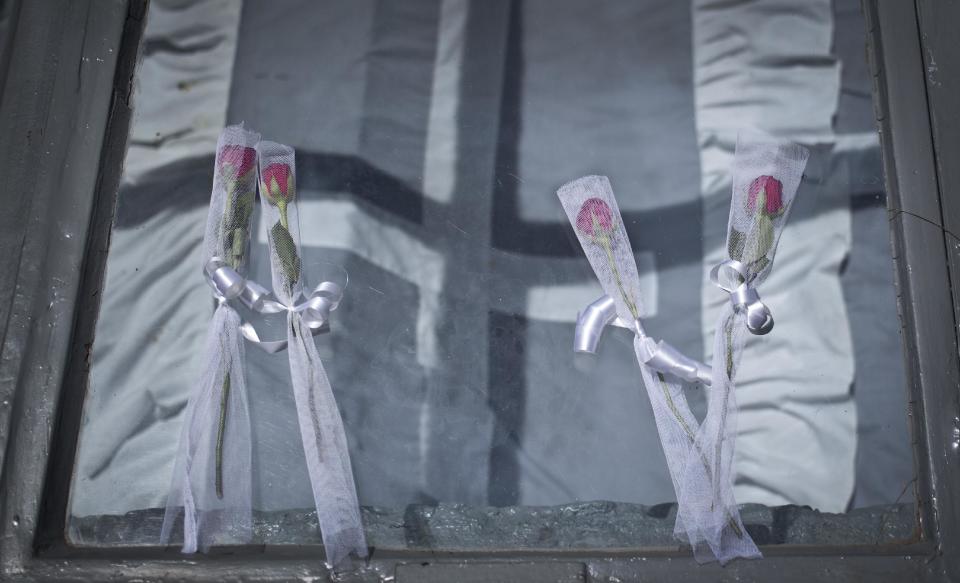 In this photo taken Tuesday, March 25, 2014, roses lie on top of one of the burial chambers that according to the Center hold over 250,000 victims of the genocide, in the gardens of the Genocide Memorial Centre in Kigali, Rwanda. Although Rwanda has made significant progress since the genocide, ethnic tensions remain. (AP Photo/Ben Curtis)