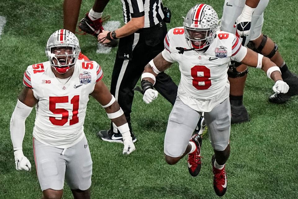 Ohio State defensive end Javontae Jean-Baptiste (8) and Ohio State defensive tackle Michael Hall Jr. (51) celebrate the sack on Georgia quarterback Stetson Bennett during the first half of the Peach Bowl NCAA college football semifinal playoff game, Saturday, Dec. 31, 2022, in Atlanta. (AP Photo/Brynn Anderson)