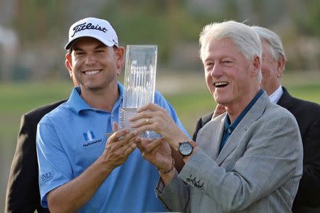 Jan 25, 2015; La Quinta, CA, USA; Former president Bill Clinton (right) presents Bill Haas with the Humana Challenge trophy at PGA West - Arnold Palmer Private Course. Jake Roth-USA TODAY Sports