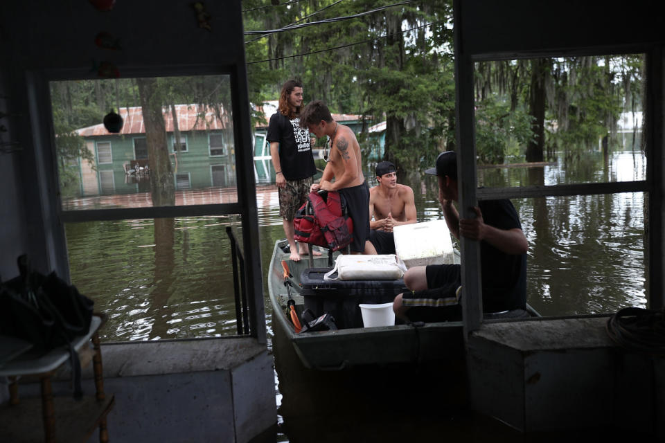 Bryce Richard, Nick Rome and Blake Waguespack (L-R) wait in the boat for a friend to check out her flooded house in Sorrento, La. (Photo: Joe Raedle/Getty Images)