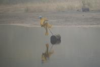 A scarecrow floats on the surface of a tailings pond to keep birds from landing in the toxic wastewater from oil production near Fort McMurray, Canada, on Saturday, Sep. 2, 2023. (AP Photo/Victor R. Caivano)