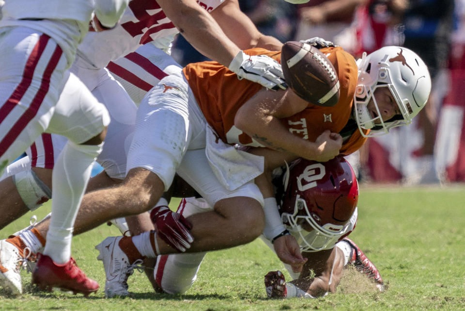 FILE - Texas quarterback Quinn Ewers (3) fumbles as he is hit by Oklahoma defensive back Peyton Bowen during the second half of an NCAA college football game at the Cotton Bowl, Oct. 7, 2023, in Dallas. Bowen, a freshman at strong safety, has blocked two punts — one for a safety — leads the Sooners with four pass breakups. (AP Photo/Jeffrey McWhorter, File)