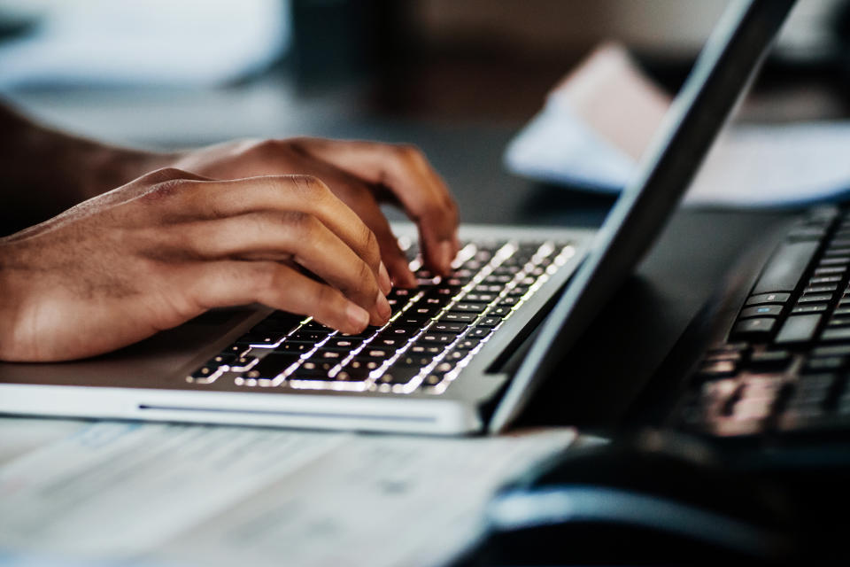 person typing up an email on a laptop